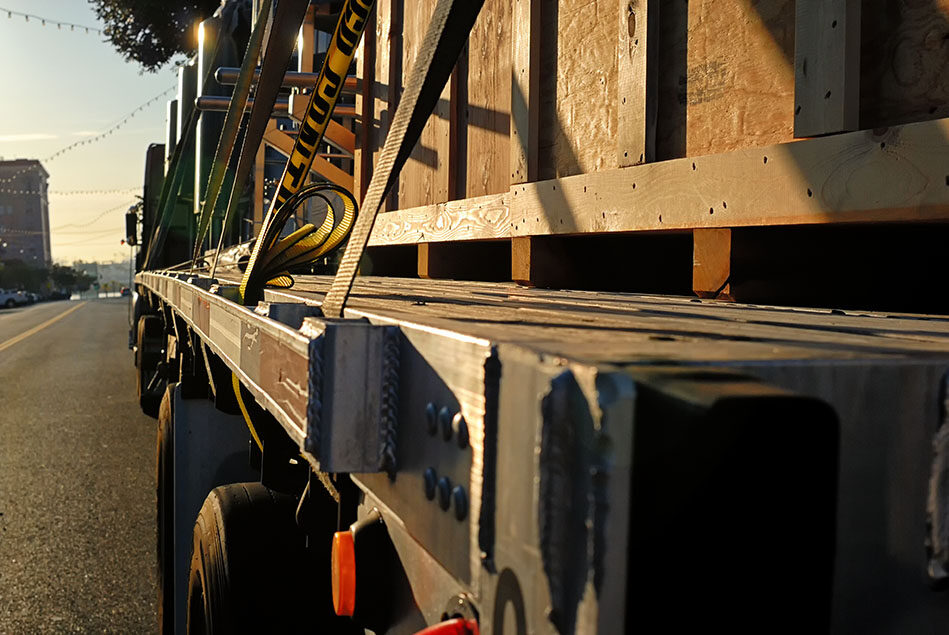 A big rig with a crated load on its flat bed.